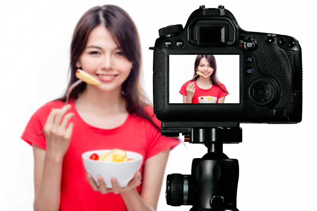 Asian Food Vlogger with Fruit Salad behind Camera
